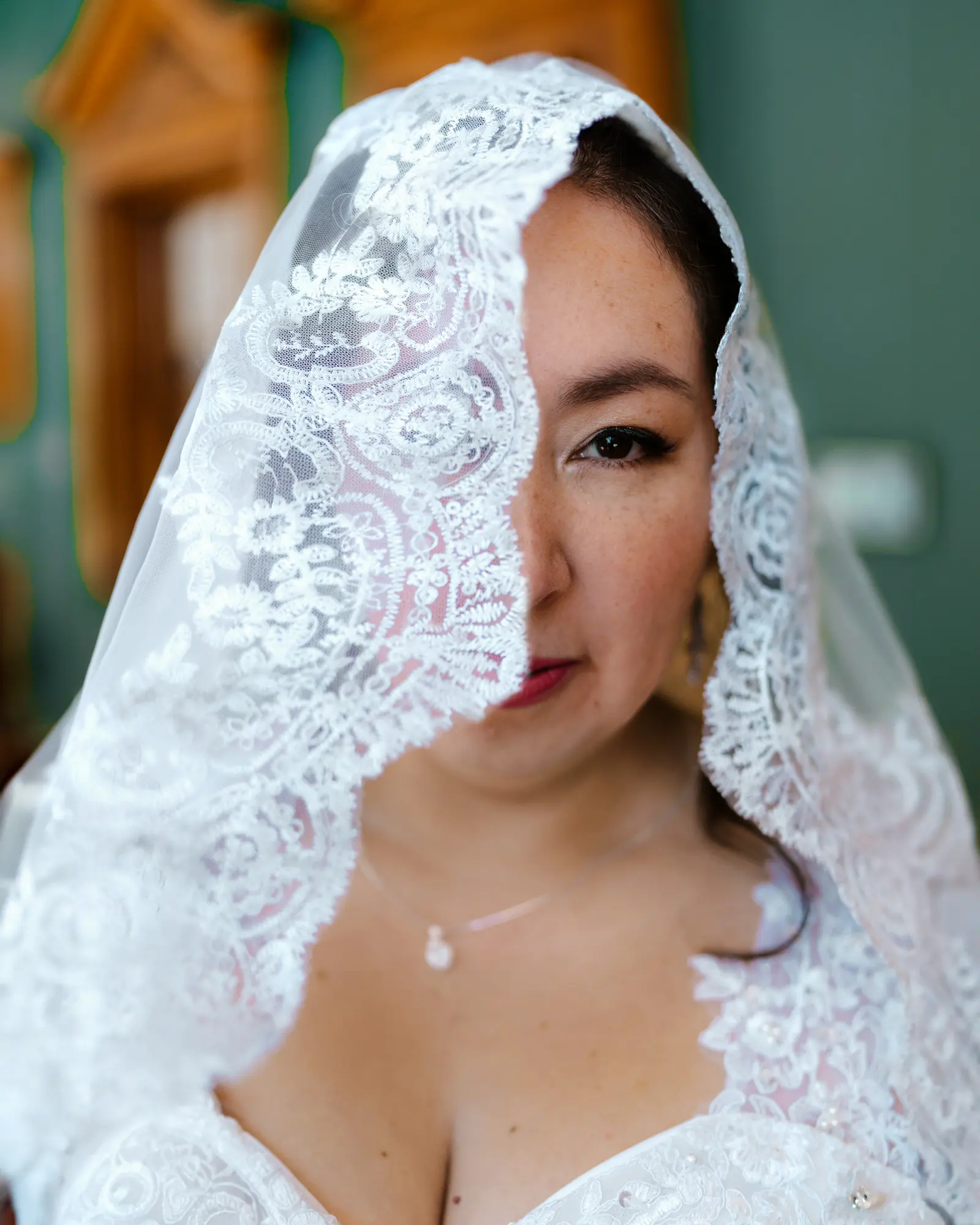Retrato de novia con velo de encaje cubriendo parte de su rostro